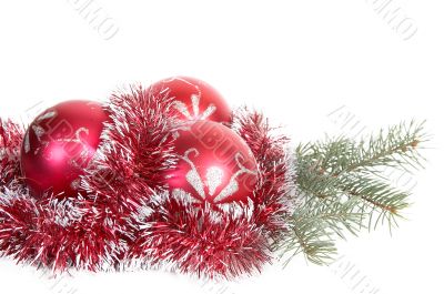 Three red christmas balls and branch of fir tree.