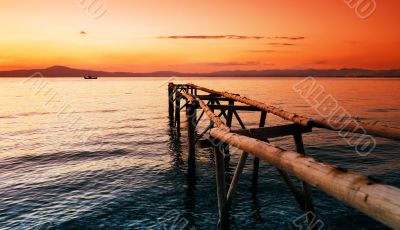 Primitive wooden pier at sunset