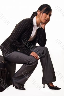 Woman sitting on luggage