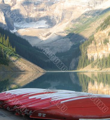 canoes by a lake and mountains