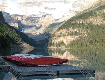 canoes by a lake and mountains