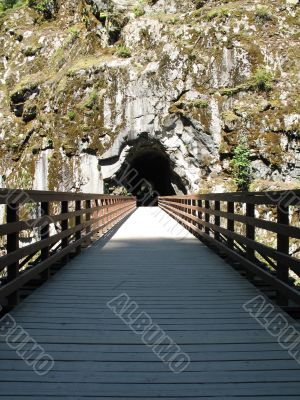 long, old wooden bridge going into a tunnel