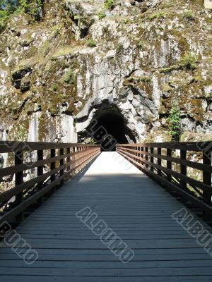 long, old wooden bridge going into a tunnel