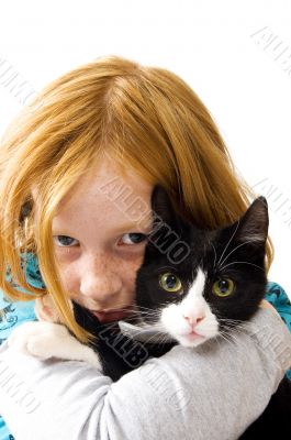 red head girl holding a black white kitten