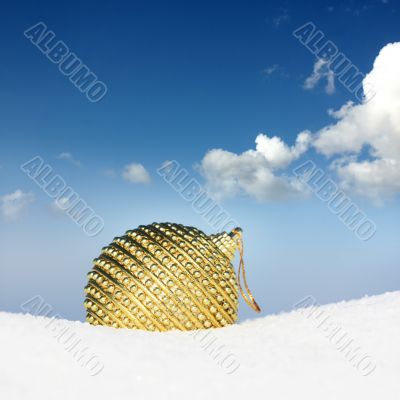golden christmas bauble in snow