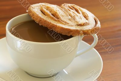 Cup of hot coffee and palmier cookie