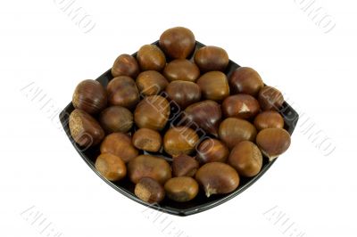 Chestnuts on dark plate isolated on white background