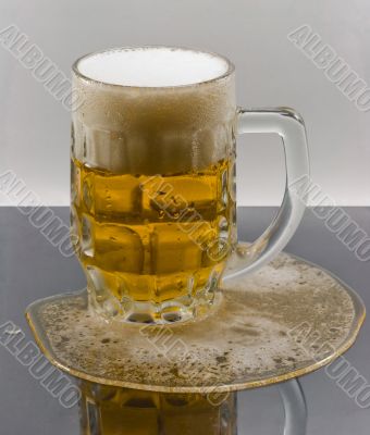 Light beer in the mug on wet surface