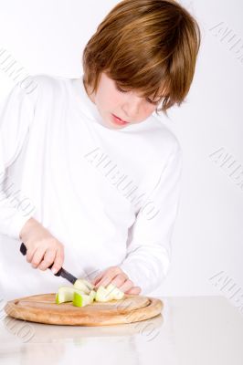 Young boy cuts the apple