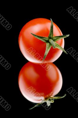 Ripe tomato on black background