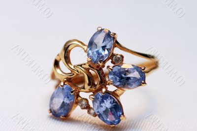 blue topaz on golden rings isolated on white background