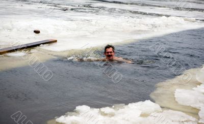 The man bathes in an ice-hole