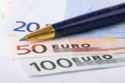Euro banknotes and pen