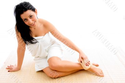 woman scrubbing her leg on an isolated background