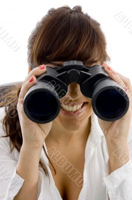 smiling businesswoman looking through binoculars