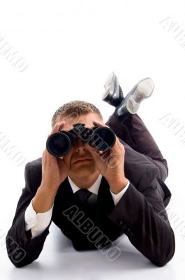 executive lying on floor and using binoculars