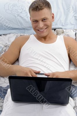 smiling laying male holding laptop
