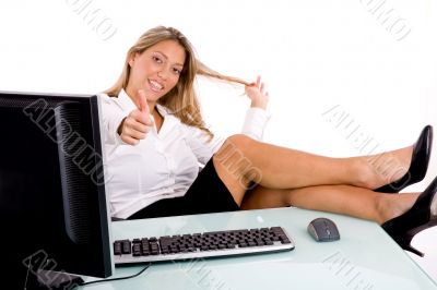 smiling businesswoman showing thumb up in office