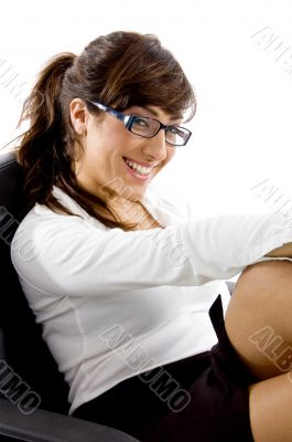 side view of smiling woman sitting on chair