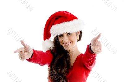 woman with christmas hat pointing with both hands