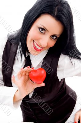 woman smiling and holding a small red heart
