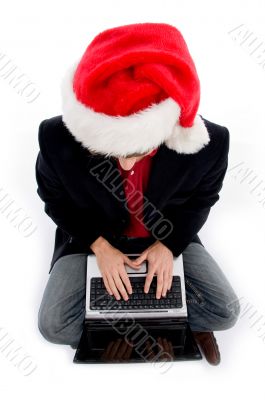 male with christmas hat and working on laptop