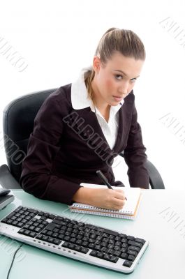 blond professional writing on notebook