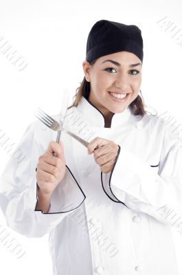 young chef holding metal cutlery