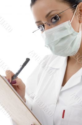 female doctor with mask and writing prescription
