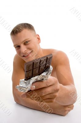 smiling muscular man showing chocolate