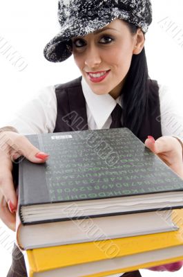 student in cap holding stack of books
