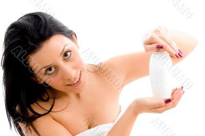female posing with lotion bottle on an background