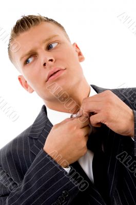 corner view of businessman tucking his button