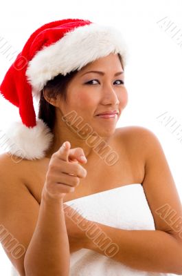 young woman with christmas hat pointing towards