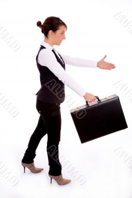 businesswoman holding bag and offering handshake