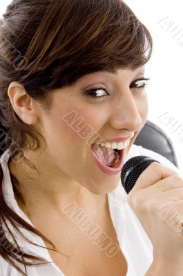 smiling female singing on microphone