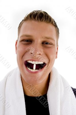 man holding white capsule between his teeth