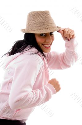 side pose of smiling model holding hat