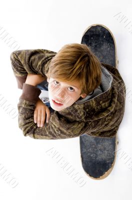 top view of boy sitting on skateboard