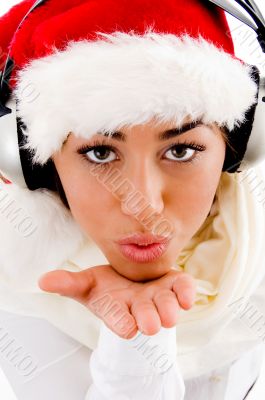 woman wearing christmas hat giving blowing a kiss