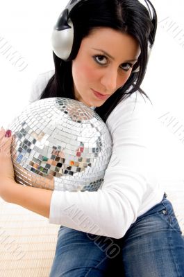 female listening music and holding disco ball on w