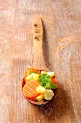 vegetablesi on a wooden spoon
