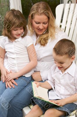 Young Boy Reads to His Mother and Sister