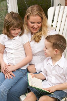 Young Boy Reads to His Mother and Sister