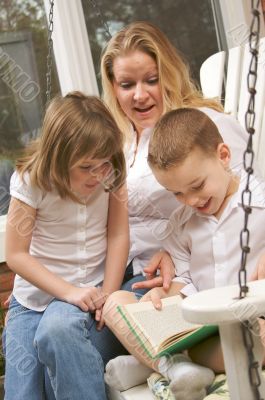 Young Boy Reads to His Mother and Sister