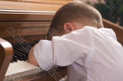 Young Boy with Head on the Piano