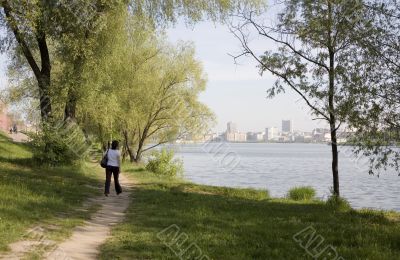 Woman on the road near the city lake