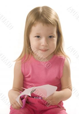 pretty small girl is cutting paper heart shape