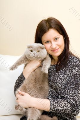 The girl holds a grey cat on hands