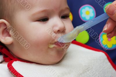 Mother feeding baby food to baby
